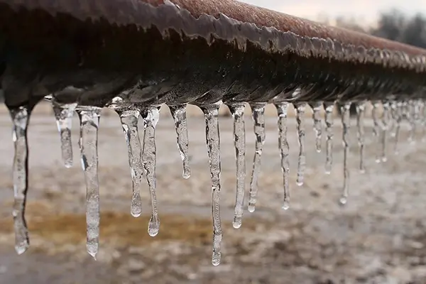 Frozen pipe with ice buildup during winter weather damage